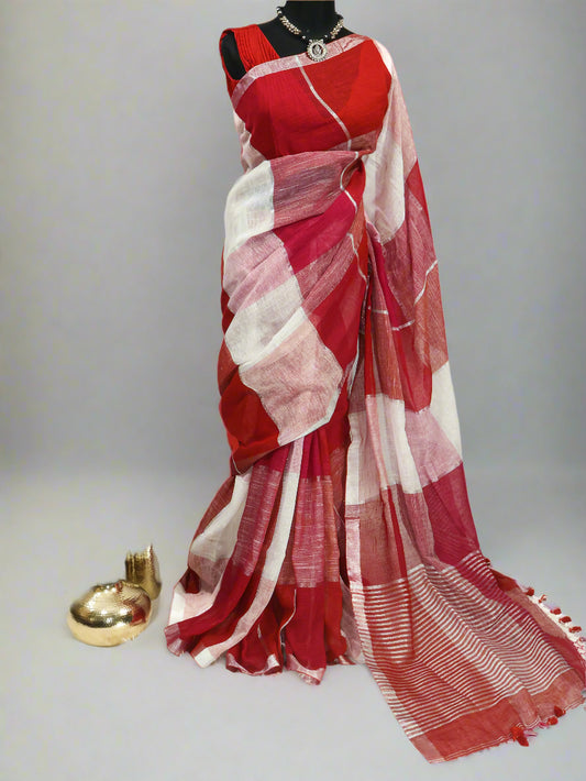 A red, pink, and silver linen saree displayed on a model, featuring geometric patterns and tassels.
