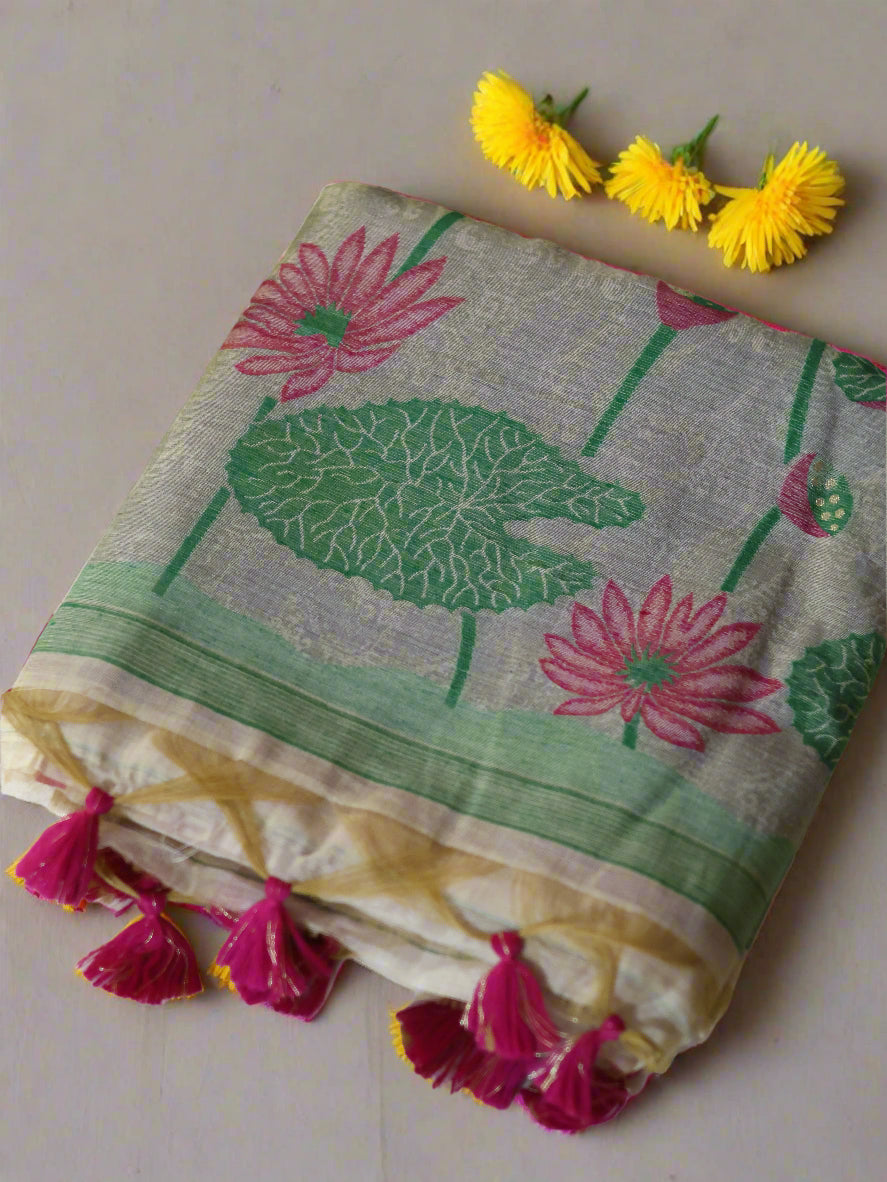 Muga cotton silk saree with thread woven pink lotus design, displayed on a white surface with a pink and green floral pattern, including a matching pink blouse piece.