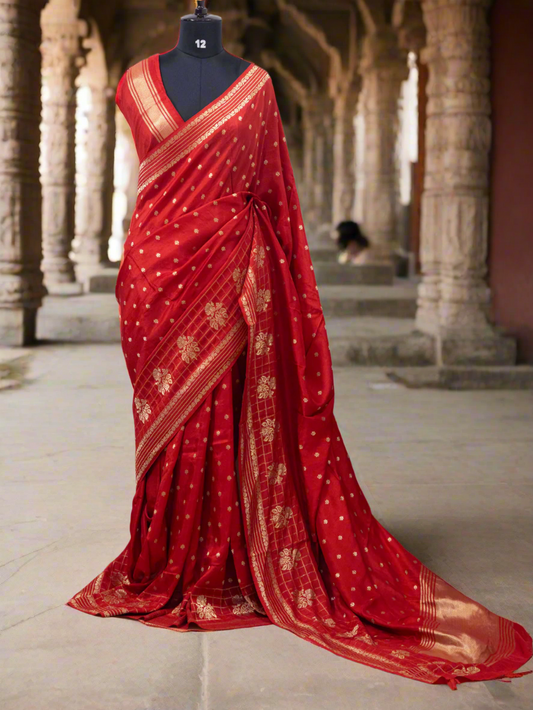 Red saree with gold patterns on a mannequin against a white curtain background, branded 'Aurat Designs'.