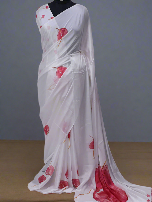 White saree with red floral patterns on a white background, branded 'AURAT DESIGNS'.